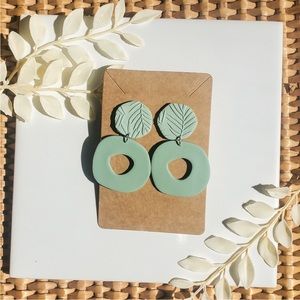 Handmade sage green polymer clay dangle earrings.